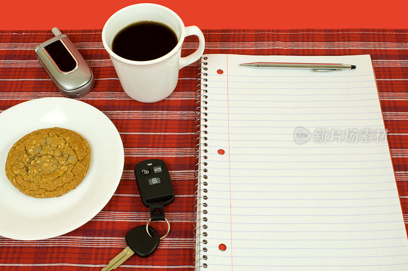 一杯咖啡和红色格子图案的螺旋笔记本