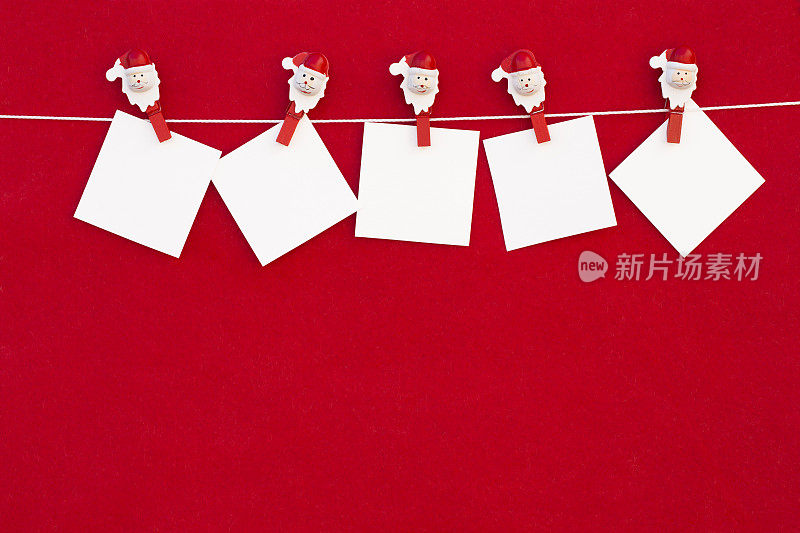 红色背景上挂着晾衣绳的圣诞空白字条