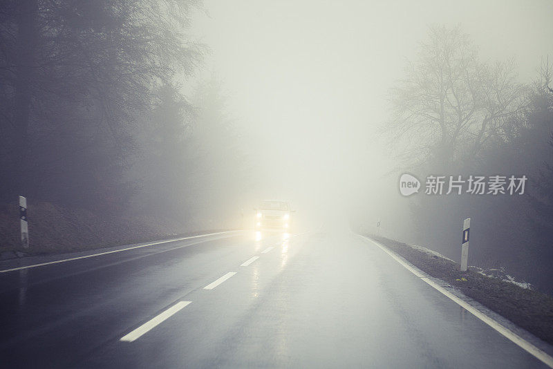 乡村道路上有浓雾，迎面驶来的车辆