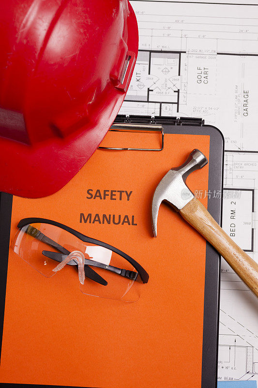施工:图纸上的安全手册和工人工具。