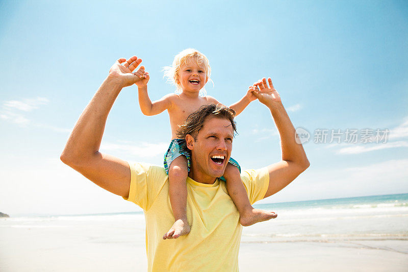 快乐的父亲和他的小儿子在海滩上玩