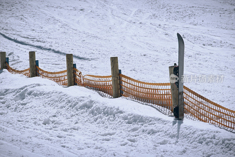 斜靠在滑雪场防护篱笆上的滑雪板