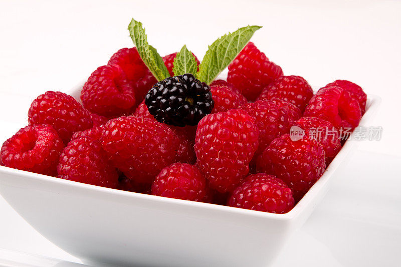 覆盆子，单黑莓，薄荷叶放在白色碗里