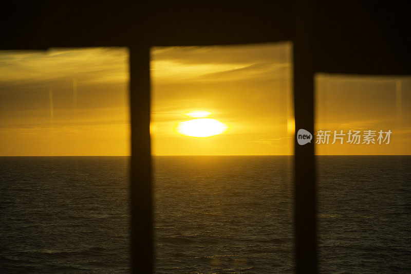 美丽的日落透过船的窗户在海上