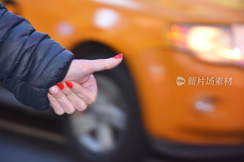 一位女士在纽约拦下一辆黄色出租车