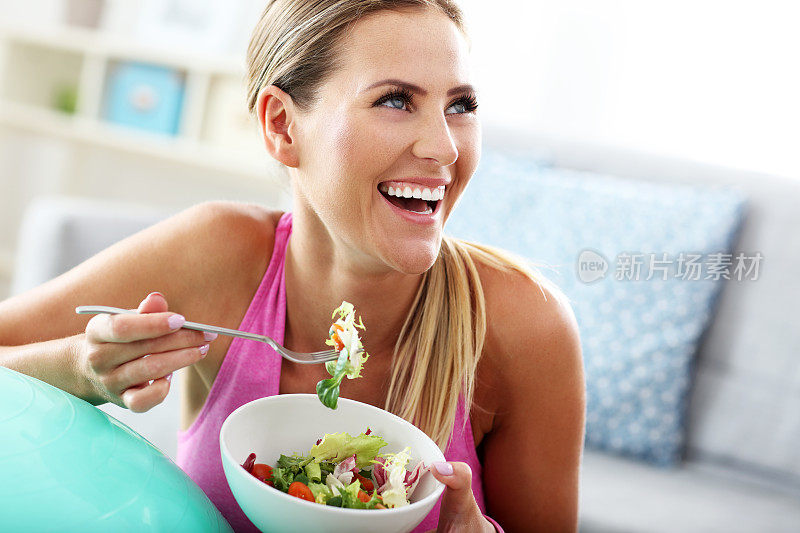 年轻女子在锻炼后吃健康的沙拉