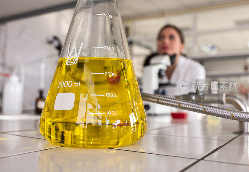 近距离观察实验室中带有黄色化学液体的烧杯。