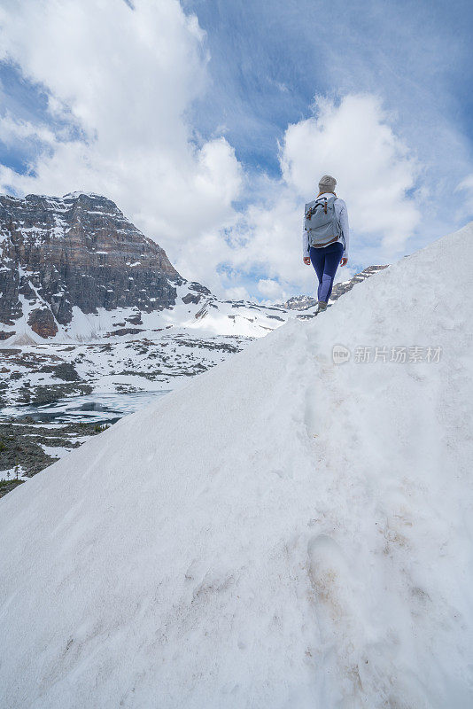 年轻女子在雪道上徒步旅行