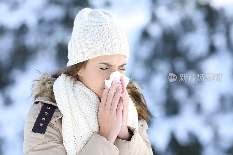 一个女人在寒冷的雪天里吹纸巾