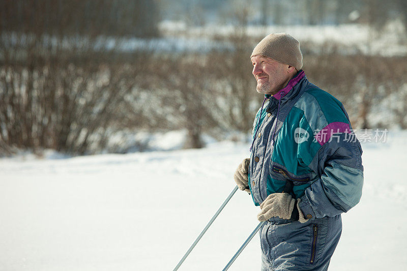 一个成熟的男人在冬天的森林里滑雪