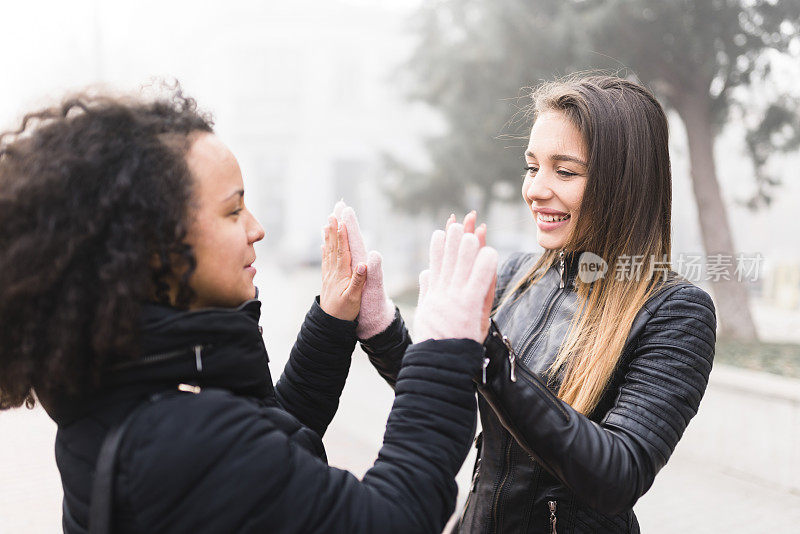 两名多民族女性在雾中触摸手指