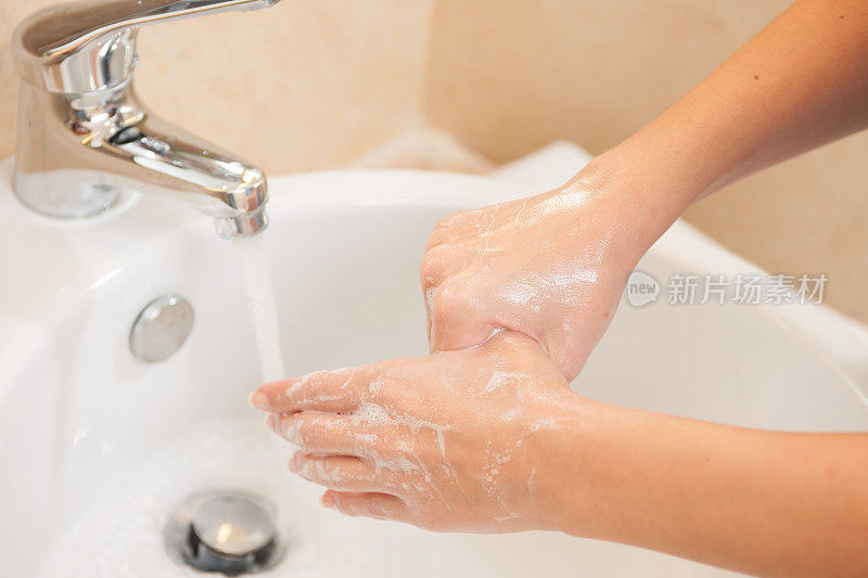 在水槽里用肥皂洗手的女人