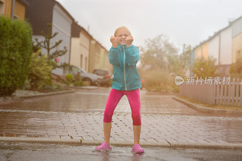女孩在雨中玩耍在一个夏天的一天