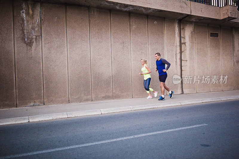 一对年轻的运动员在城市环境中做晨跑