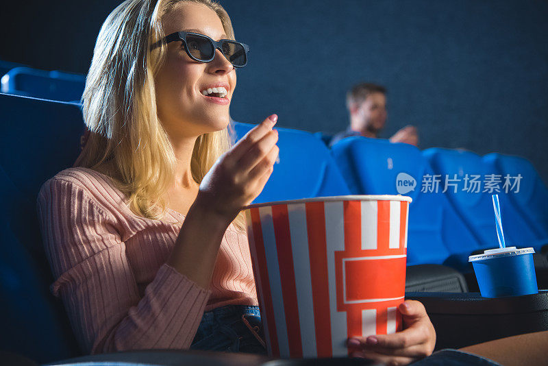 带着3d眼镜，带着爆米花独自在电影院看电影的女人