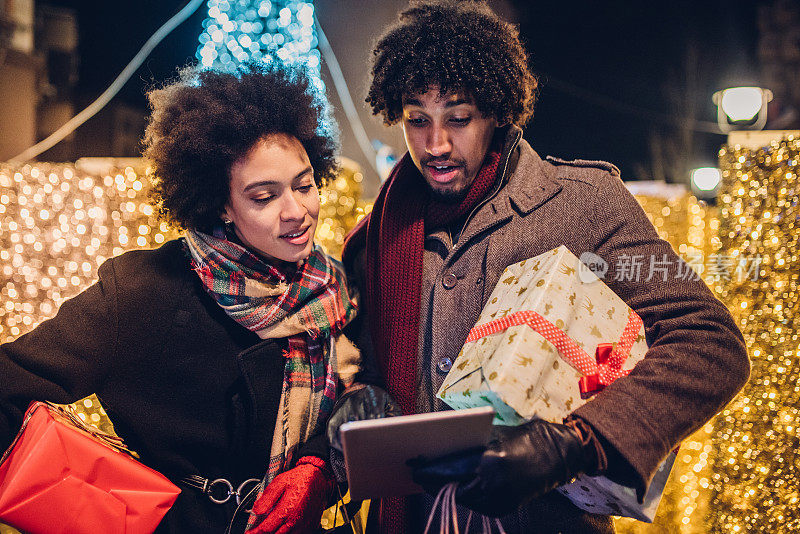 一对年轻夫妇用平板电脑在网上购买圣诞礼物