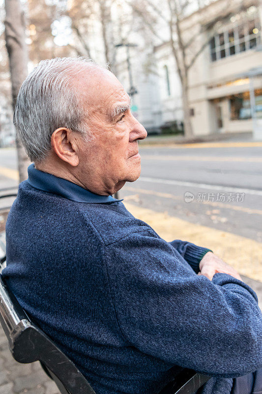 坐在城市长椅上的老人