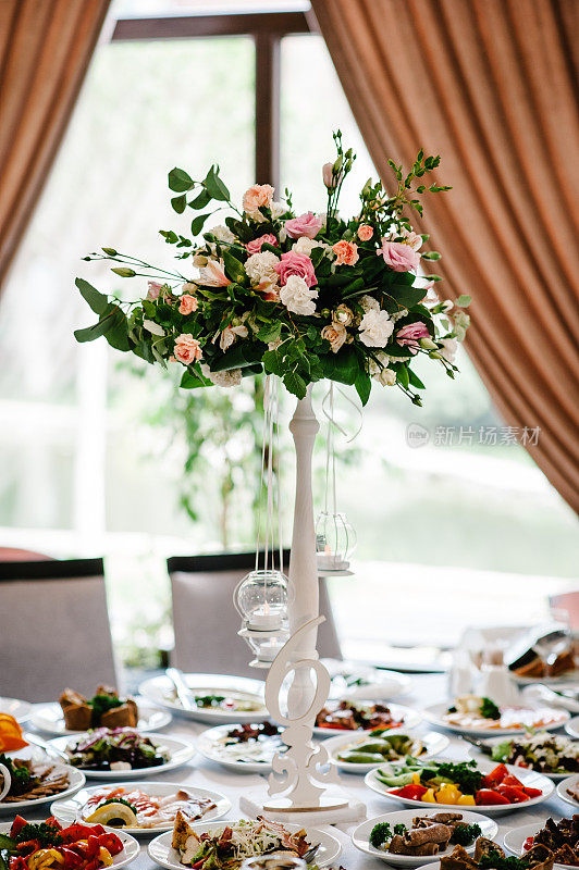 婚礼宴会厅的喜庆桌上摆着一幅鲜花和绿色的构图。站,标志号码。关闭了。