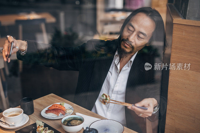 绅士在餐厅吃寿司时自拍