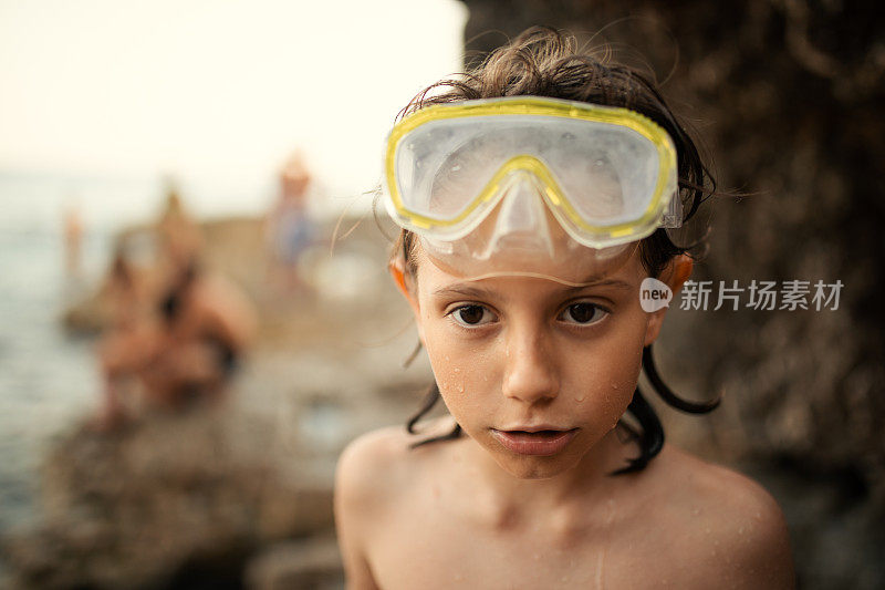 小男孩戴着潜水面罩在海滩上