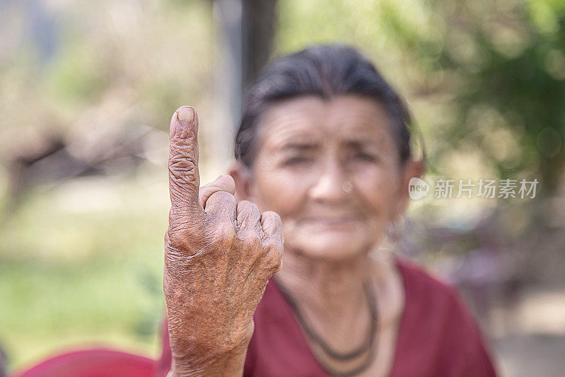 一位印第安裔老妇人在投票后展示她沾有墨水的手指。