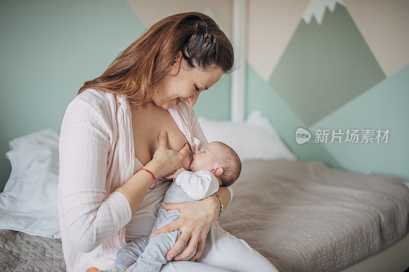 母亲在家里母乳喂养她的男婴