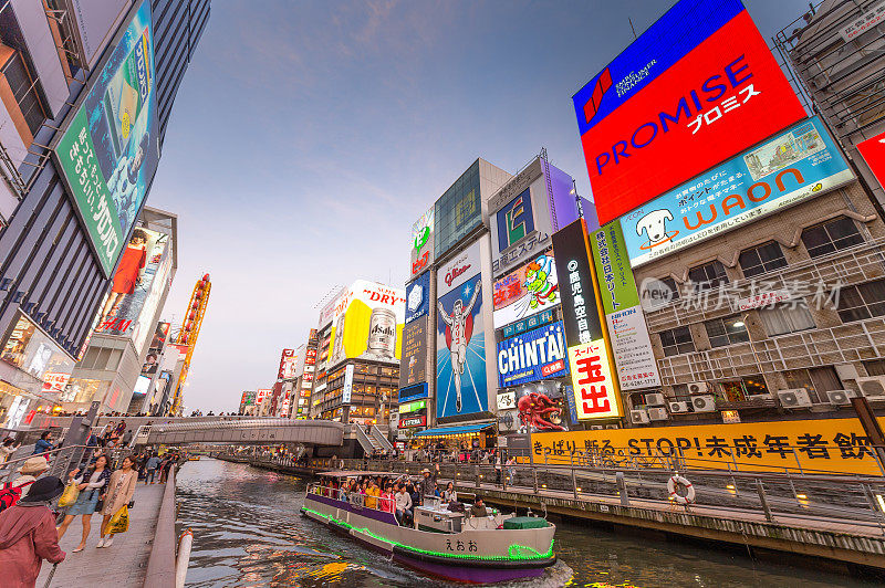 在日本大阪的道顿堀，五颜六色的广告牌照亮了大阪夜市周围的商店和零售店