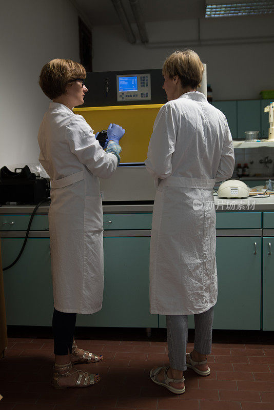 两名女科学家监督机器在测试-库存照片
