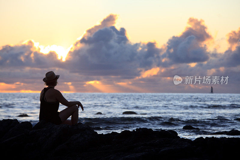 剪影的女人放松在海滩上度假