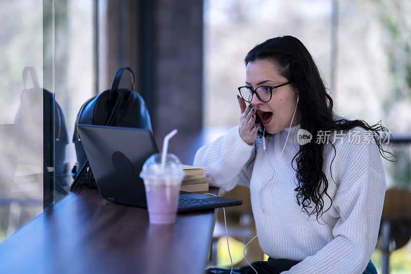 一位年轻女子正在和咖啡馆里的朋友视频聊天。