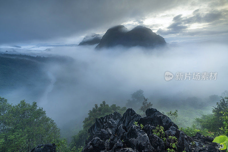 雾蒙蒙的丛林雨林与雾和分层的山脉范围从上面的日出。鸟瞰图。