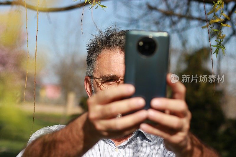 资深男士在大自然中使用电话