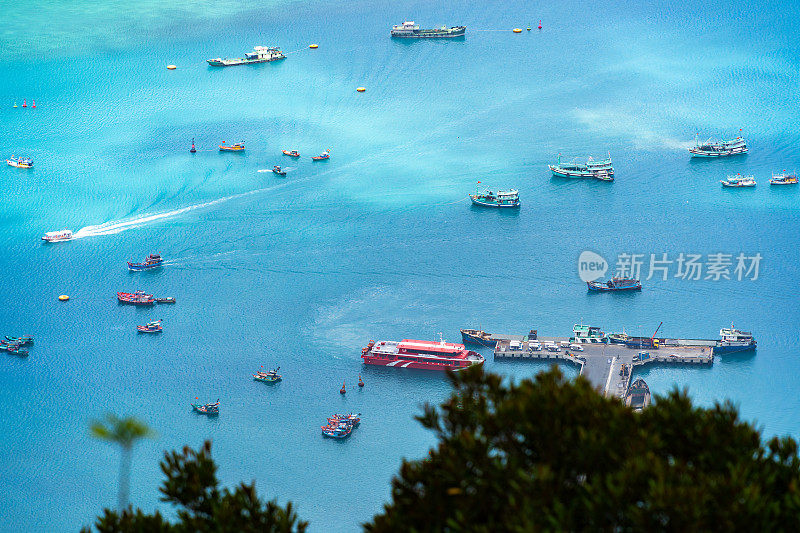 越南孔岛本丹港，湛蓝的大海，蓝天山和五颜六色的船只。