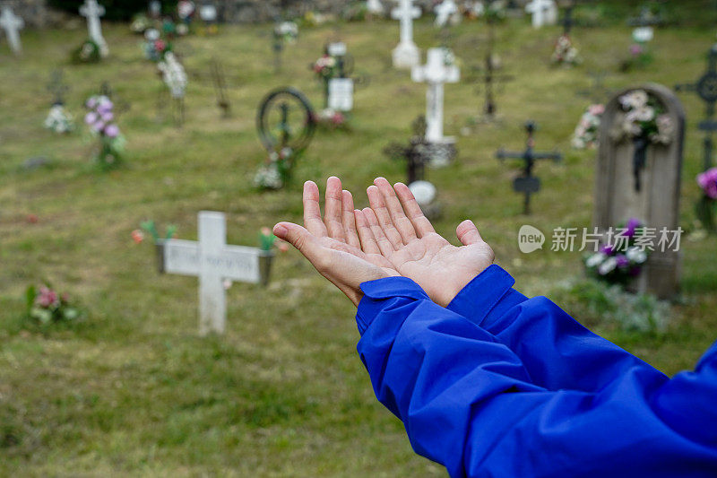 在墓地里手牵着手。用信念去信任和支持。死亡的概念，生命的终结，悲伤，悲伤和孤独。