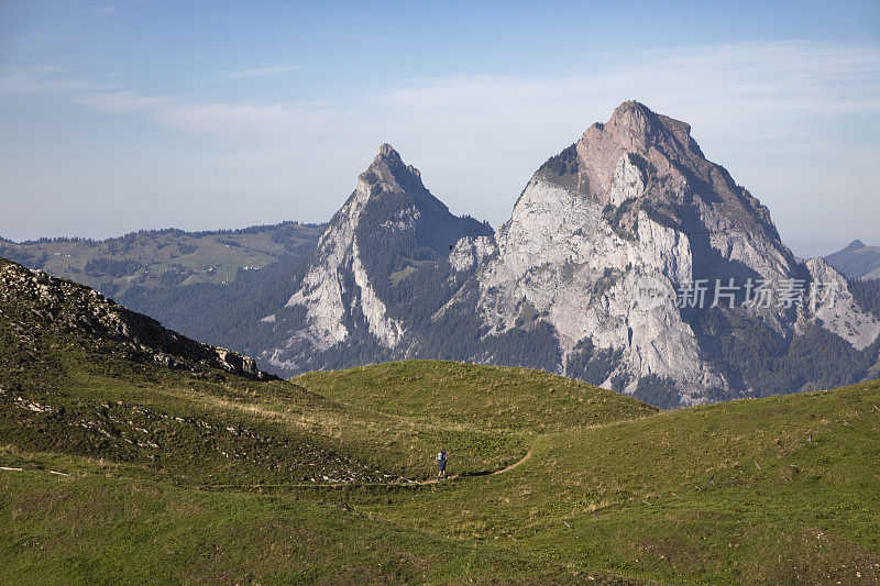 一名男子背着双肩包在斯图斯的高山徒步旅行，背景是格罗斯·迈森山和克莱纳·迈森山