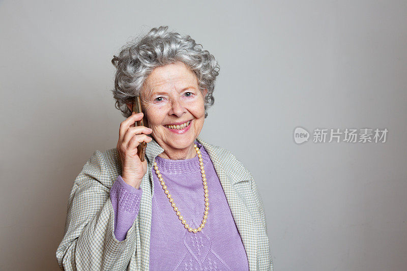 老式古怪的老年女性在电话里微笑着