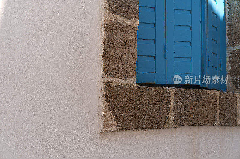 蓝色木窗穿梭在粉刷过的希腊爱琴海房产