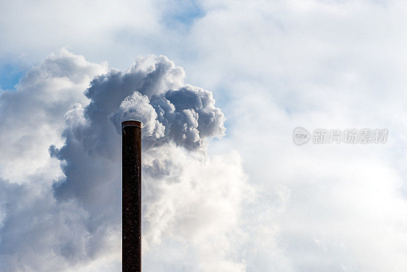 多云的天空，烟囱里的一条工业烟管。