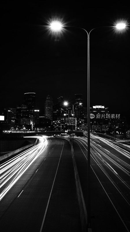 明尼阿波利斯市夜间天际线，进入I-94州际公路在明尼苏达州，美国，黑白彩色的高格式照片