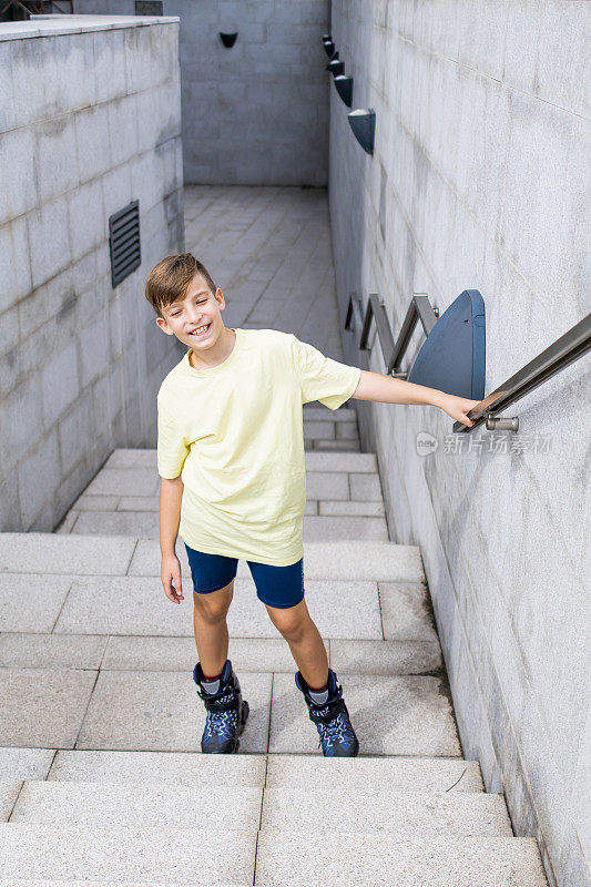 可爱的小男孩穿着旱冰鞋走下楼梯。儿童户外运动。