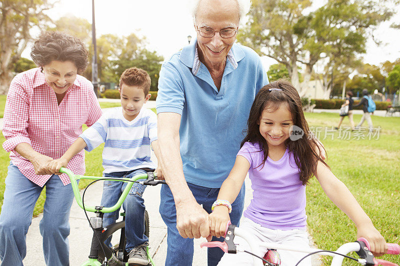 爷爷奶奶教孙子们在公园里骑自行车