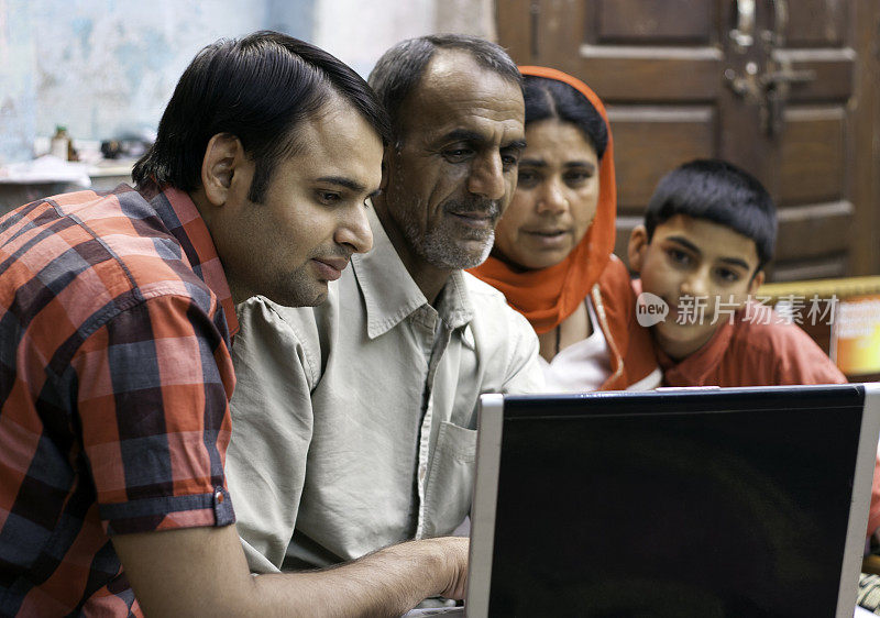 印度家庭在家里使用笔记本电脑。