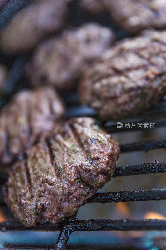 特写牛肉饼在木炭上烹饪汉堡包。