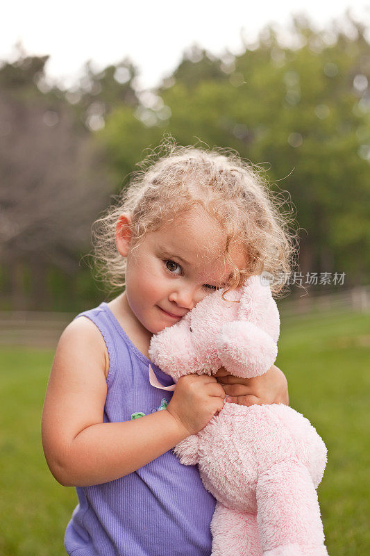 女孩拥抱粉红色的泰迪熊