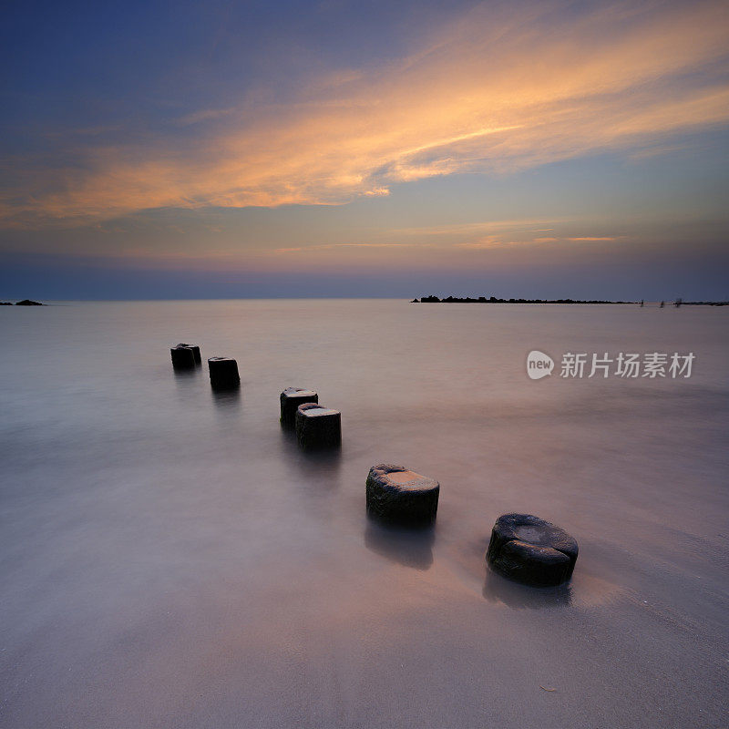 日落时分，宁静的海景和古老的木桩