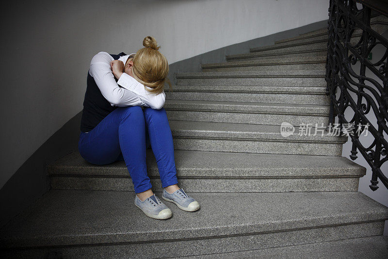 悲伤的女人坐在楼梯上