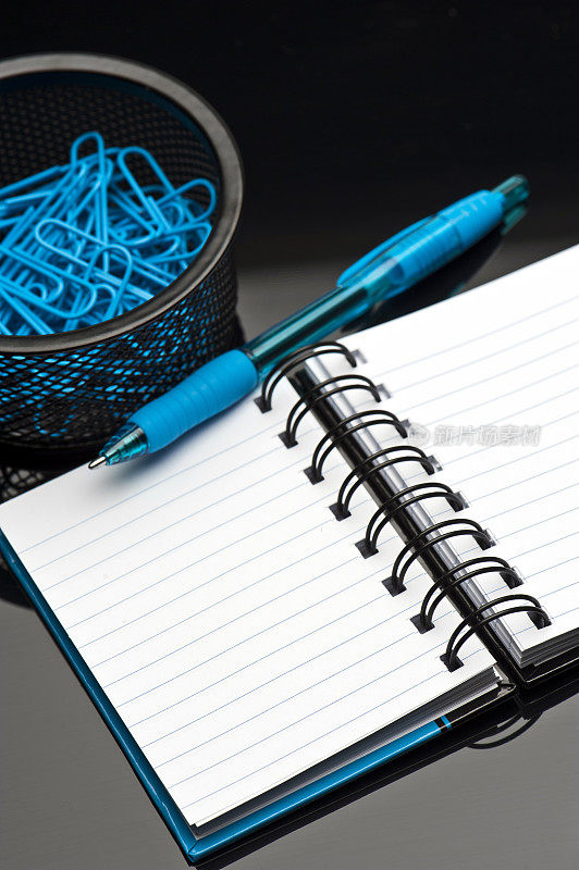 蓝色记事本，回形针和笔