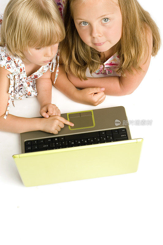 两个女孩在用笔记本电脑