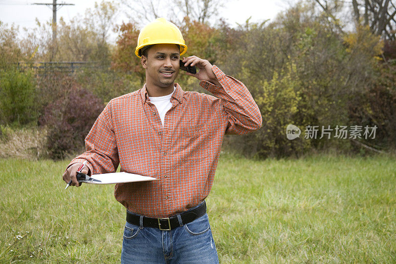 拉丁裔建筑工人对着手机微笑