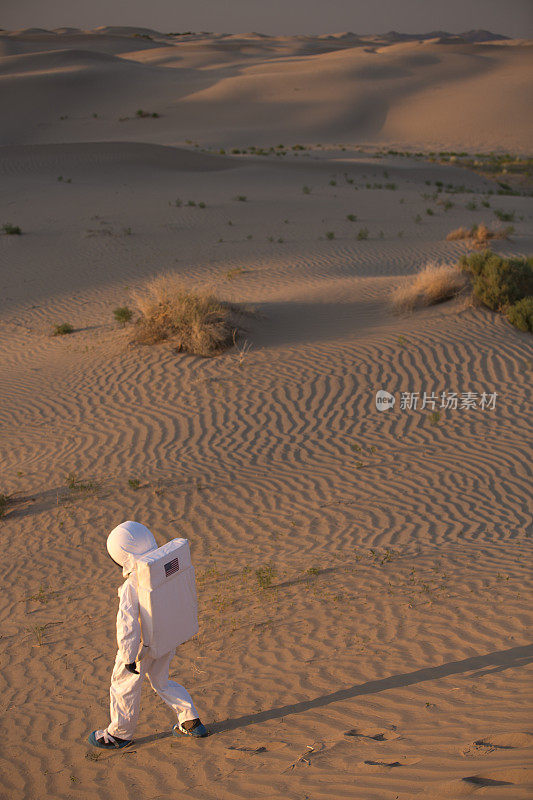 宇航员在沙丘上行走